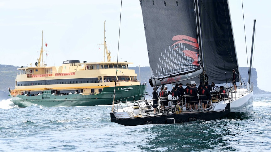 A ferry passes LDV Comanche during a practice sail ahead of Sydney to Hobart on December 20, 2017.
