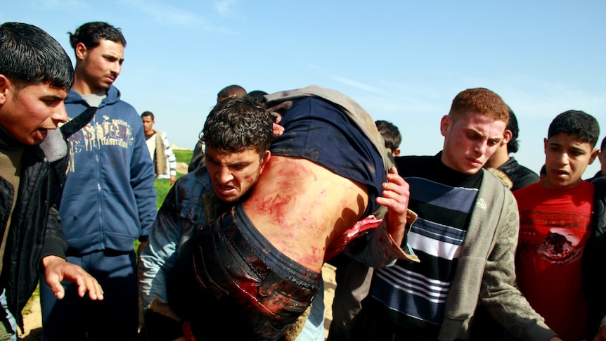Palestinians carry a wounded man to a stretcher