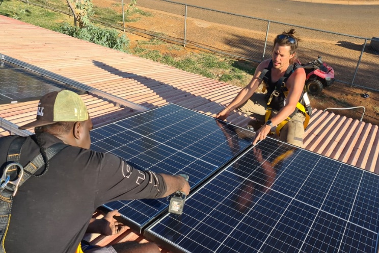 A Tennant Creek resident being trained to install solar panels on a house. 