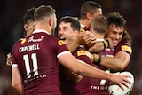 Queensland players embrace as they celebrate defeating NSW in State of Origin III.