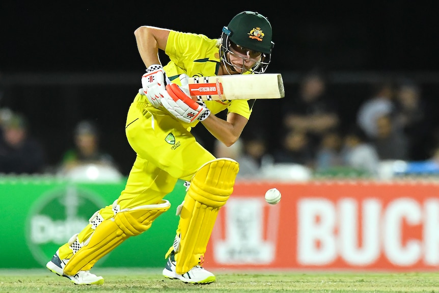 An Australia female batter plays a shot to the off side against India.