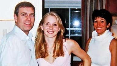 A man and two women stand in a house looking at the camera.