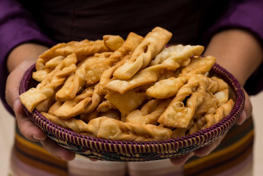 A weaved basket filled with deep fried pastry.