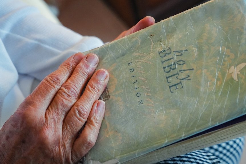 A woman's hands hold a bible.