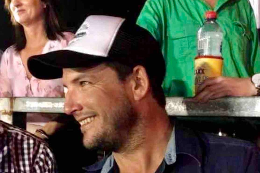 Farmer Gavin Howie sitting in a crowd, smiling.