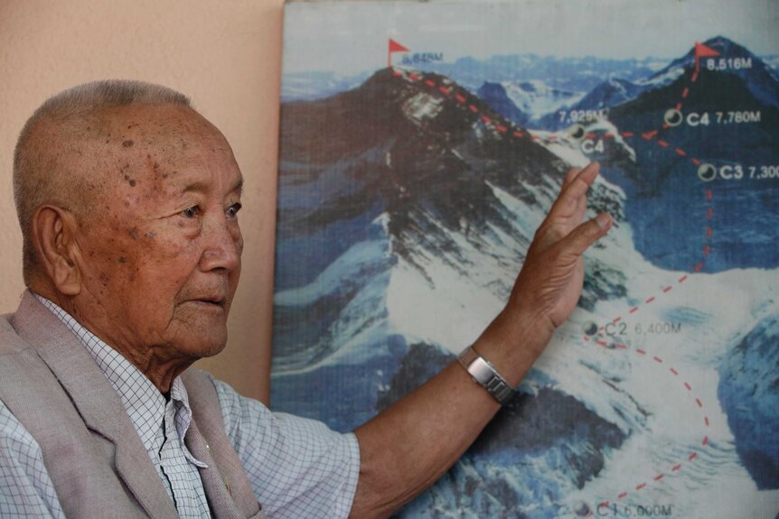 Nepalese climber Min Bahadur Sherchan, points to a picture to describe the trail to Mount Everest