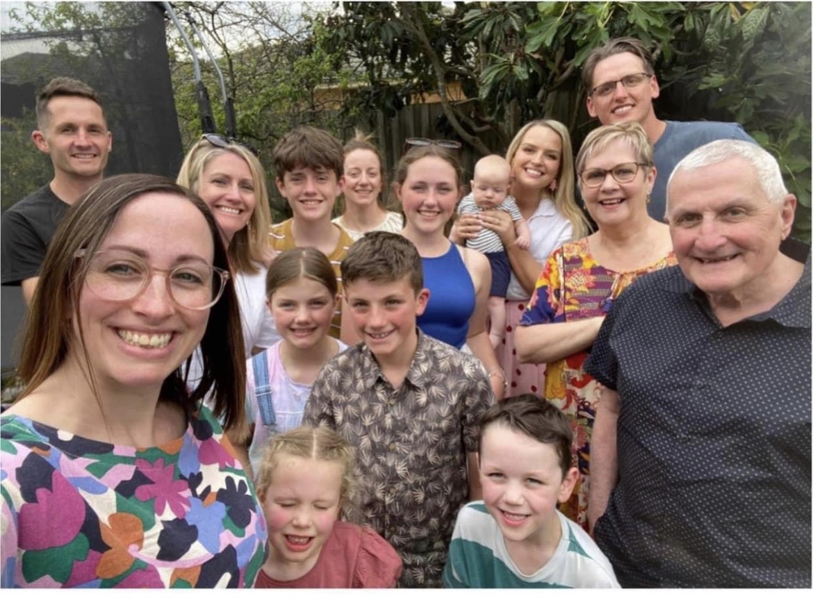 A selfie of a family of adults and children.