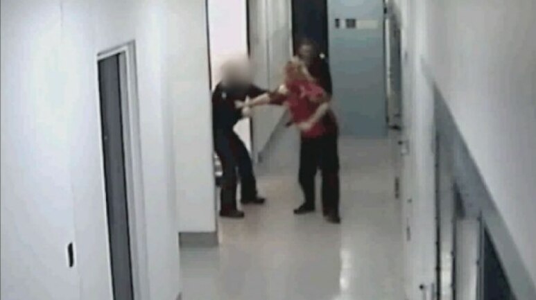 Security footage shows police using capsicum spray and kicking woman in custody.