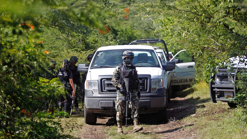 Mexican soldiers guard an area where a mass grave was found