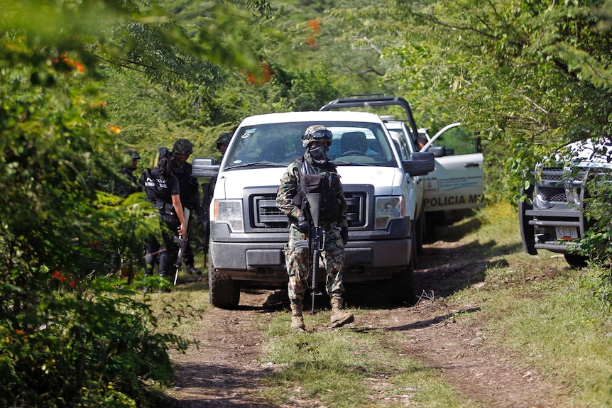 Mexican soldiers guard an area where a mass grave was found