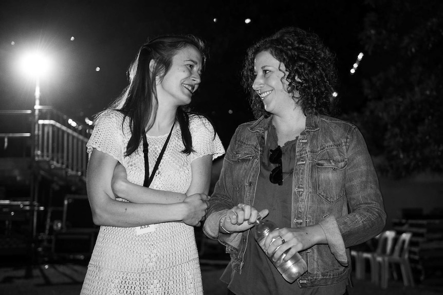 Two women stand together in black and white photograph.