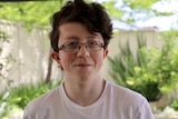 Headshot of a teenage boy wearing glasses.