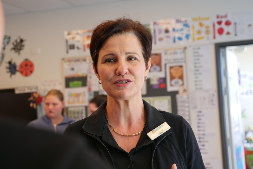 A woman in conversation, standing in a classroom with colourful pictures. Ausnew Home Care, NDIS registered provider, My Aged Care