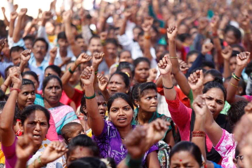 Women in saris raise their fists during a protest in Mumbai, India.