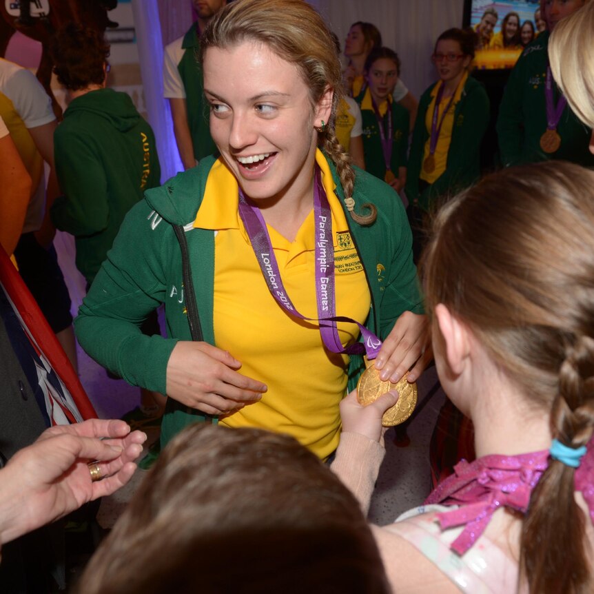 Australian Paralympian Jacqui Freney shows off one of her eight gold medals.