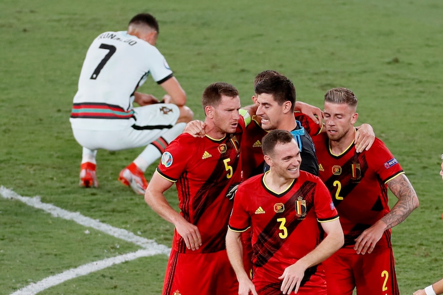 Cristiano Ronaldo reacts as Belgian players celebrate their win