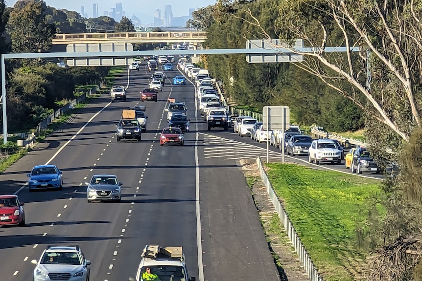 Cars queue up to exit a freeway.