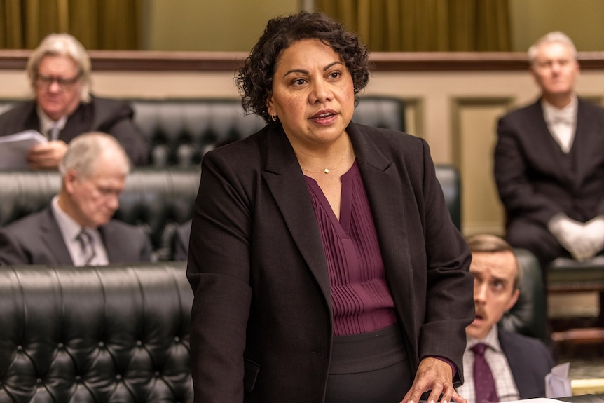 A picture from a scene of Total Control where Deborah Mailman is speaking in a parliamentary chamber