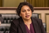 A picture from a scene of Total Control where Deborah Mailman is speaking in a parliamentary chamber
