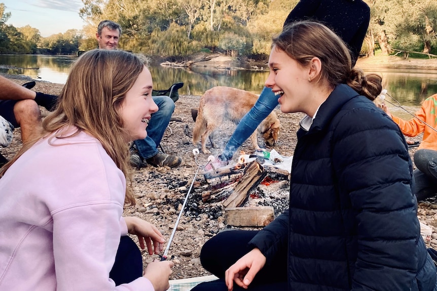 Two teenage girls by a campfire