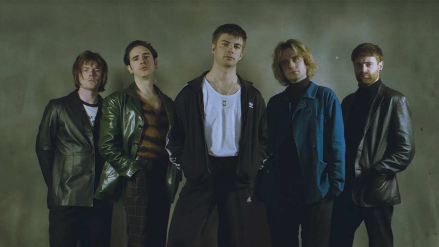 Irish indie rock band Fontaines DC stand against a grey backdrop