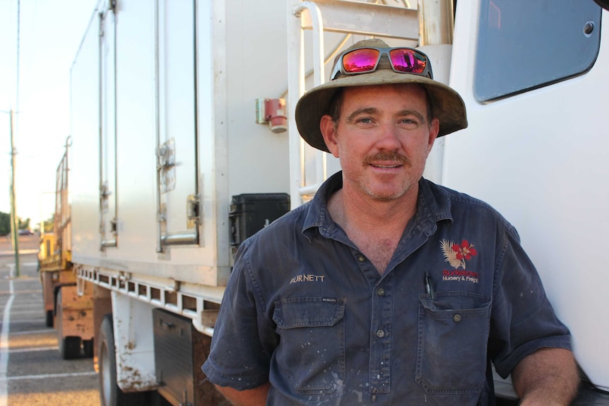 Burnette Hollingsworth stands beside his truck