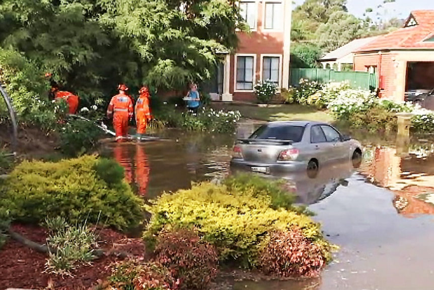 Emergency workers and a submerged car