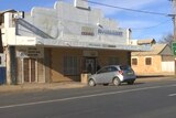 A supermarket in Wilcannia with a white car parked out the front of it.
