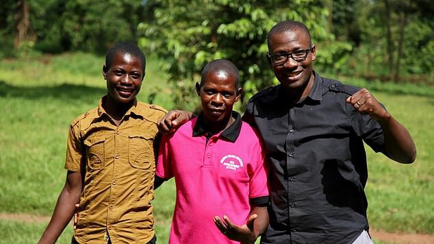 Three men stand side by side embracing all wearing bright t-shirts.