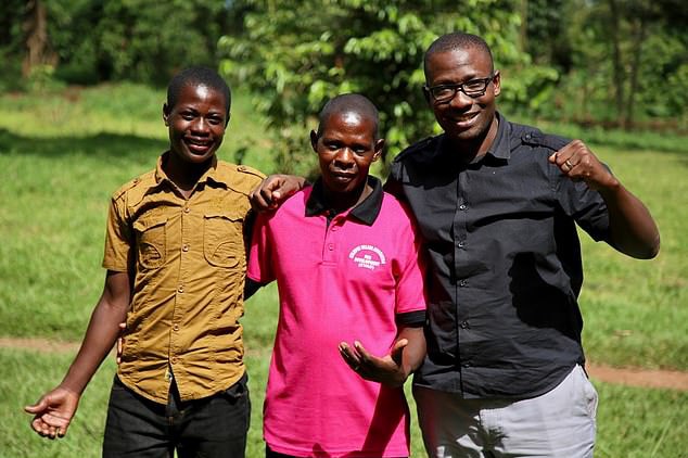 Three men stand side by side embracing all wearing bright t-shirts.