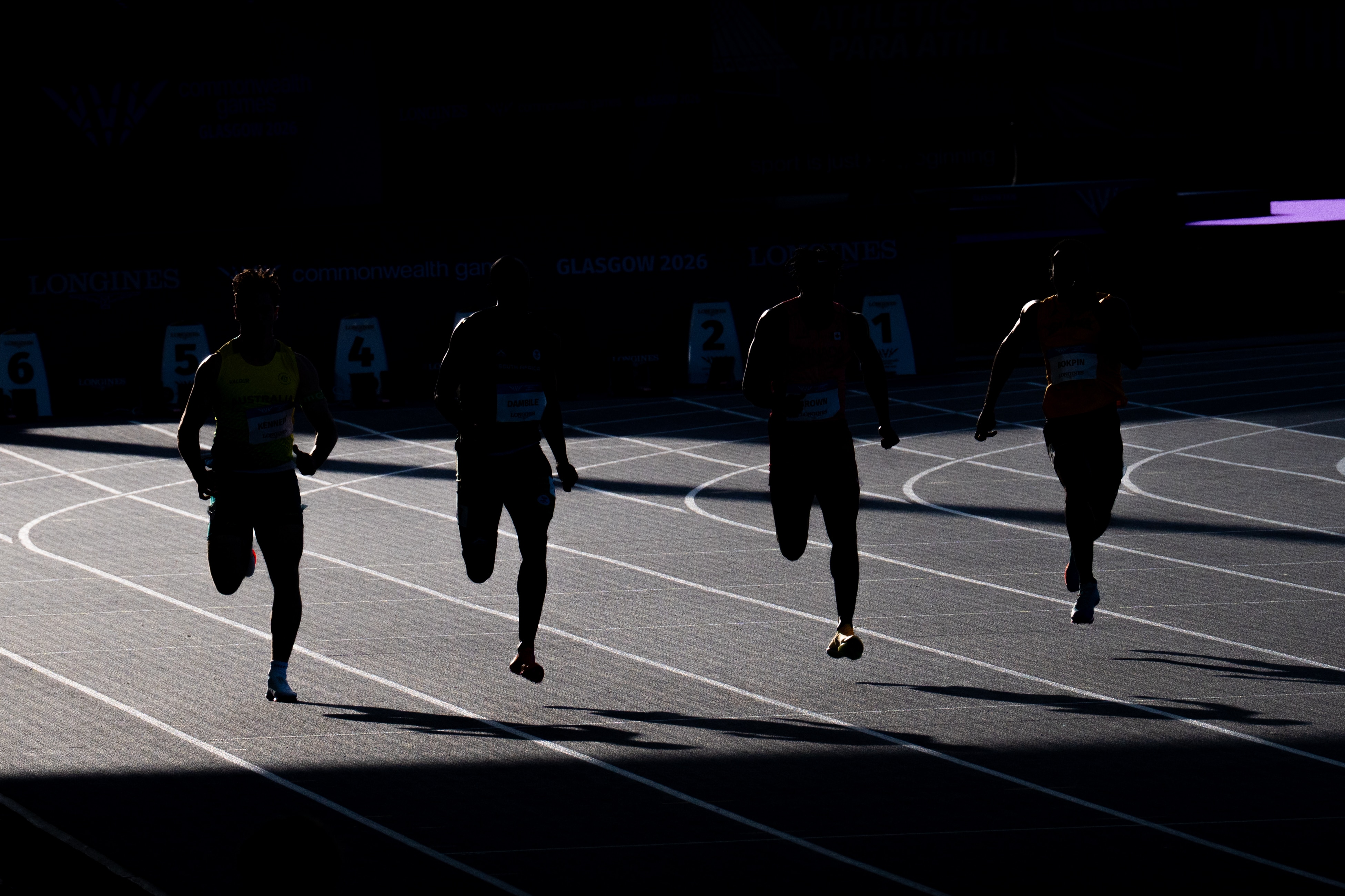 Runners silhouetted at Scotstoun Stadium during the 2026 Glasgow Commonwealth Games.