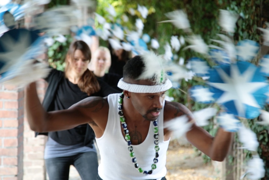 A Torres Strait Islander dancer leads a troupe of German students during a workshop.