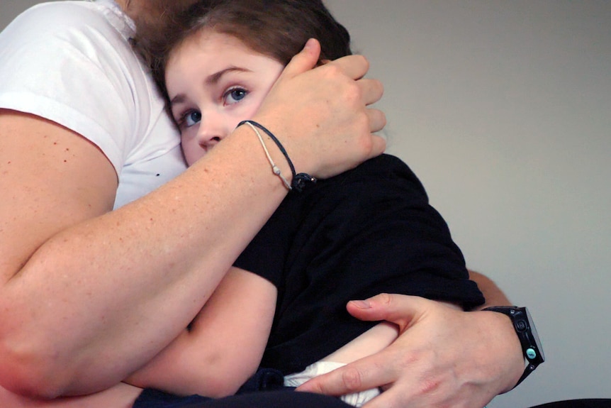 woman hugging infant girl