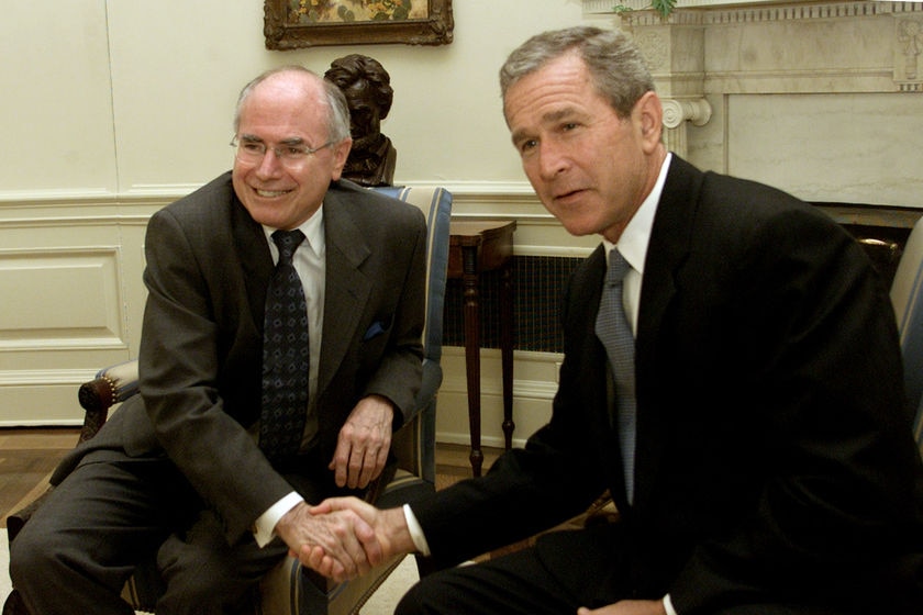 George W. Bush and John Howard shake hands in the Oval Office of the White House