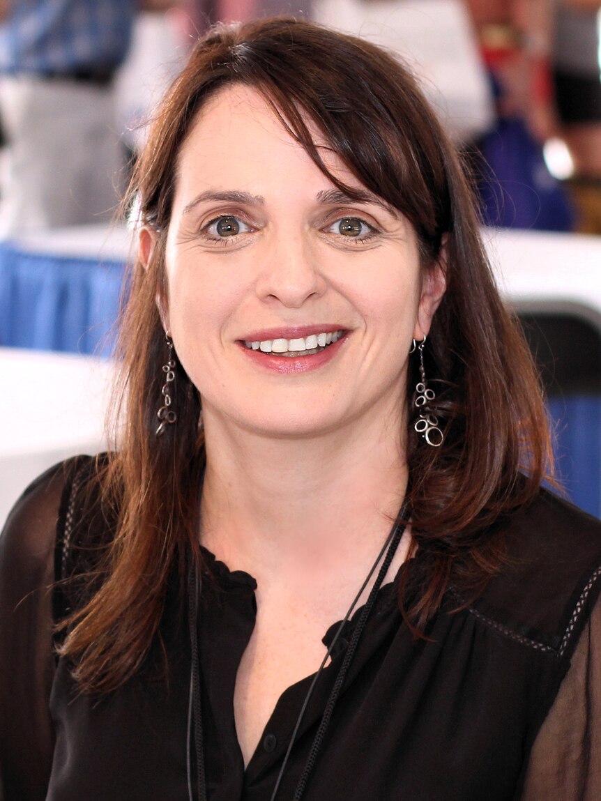 Middle aged woman with brown hair smiles at the camera at a book festival.
