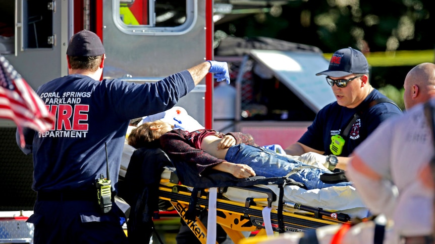 Medical personnel tend to a victim on a stretcher.