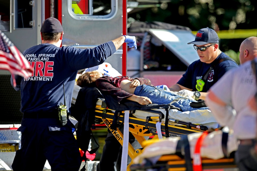 Medical personnel tend to a victim on a stretcher.