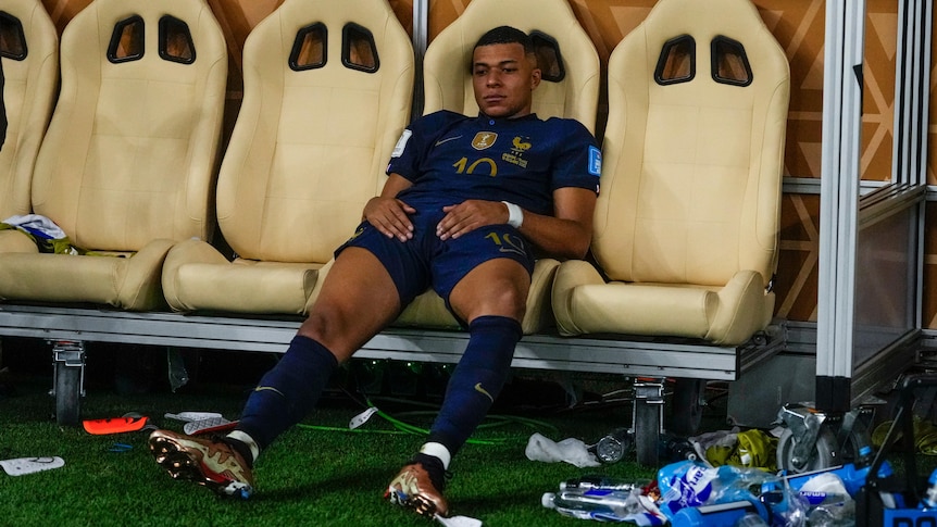 Kylian Mbappé sits slumped on a chair