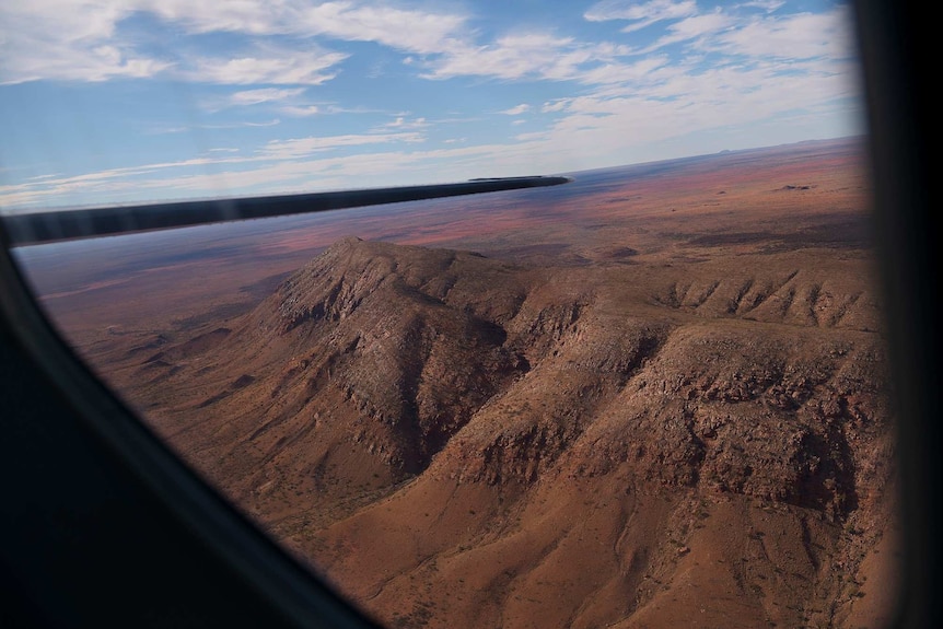 The Centipede Dreaming landscape of rolling deser hills on the flight from Haasts Bluff to Alice Springs is seen from the plane