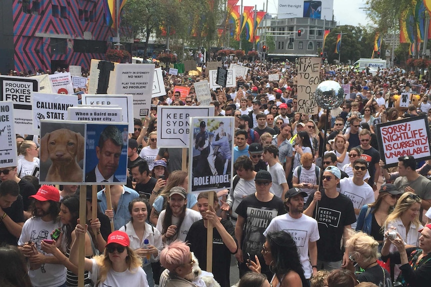 protesters carrying placard march down a street.