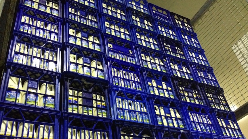 Milk bottles in crates stacked on top of each other.