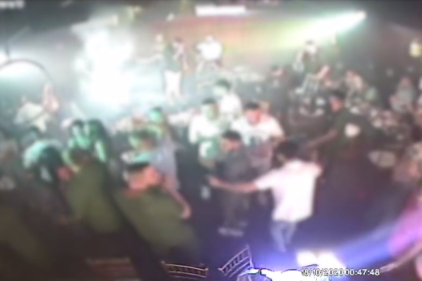 Blurred CCTV footage of a crowd of revellers dancing