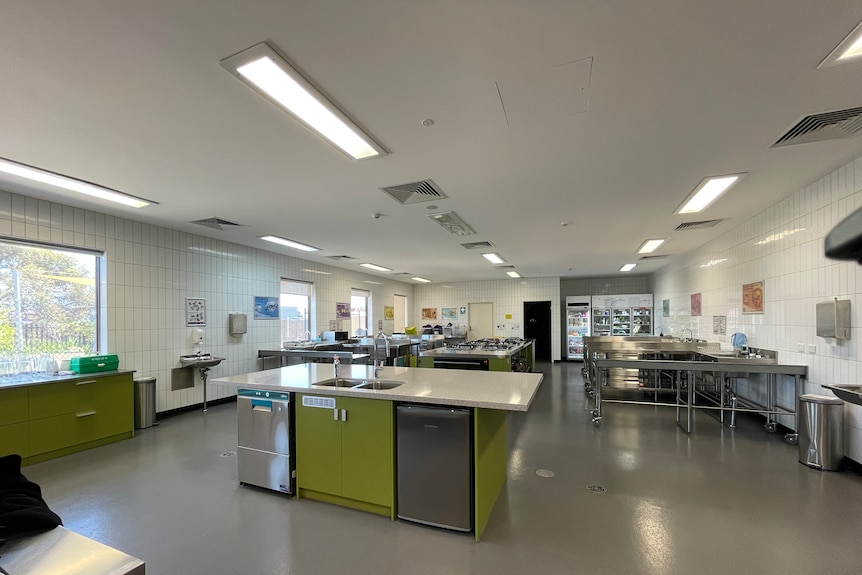 Een grote schone keuken met banken, koelkasten, diepvriezers, werkbladen die de Voedselbank heeft in hun magazijn in Perth