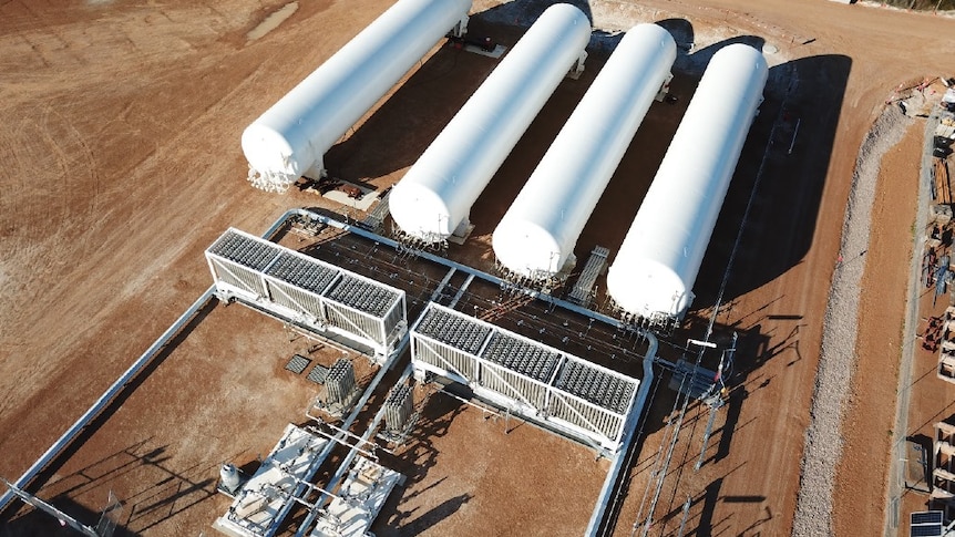 An LNG facility, looks like a series of white cylinders on red dirt