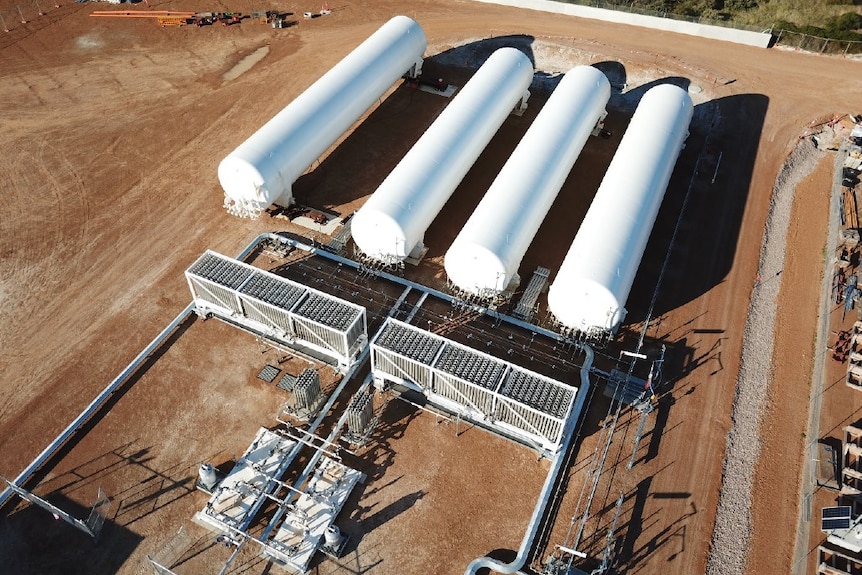 An LNG facility, looks like a series of white cylinders on red dirt