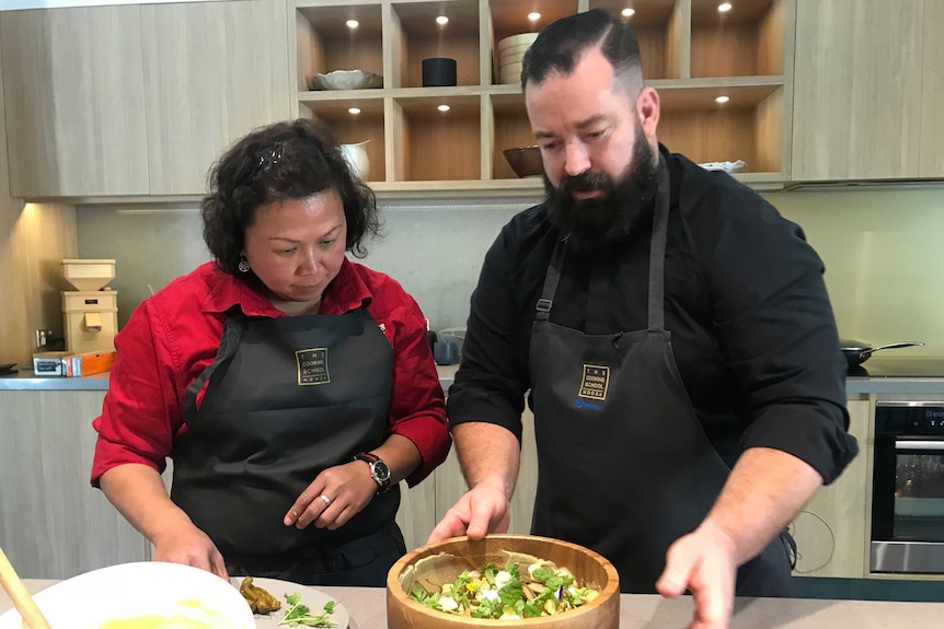 Two people preparing food in a kitchen