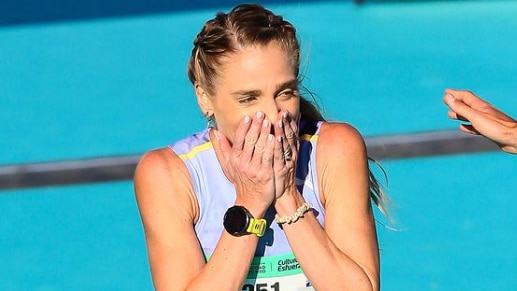 Australian female marathon runner Genevieve Gregson has her hands clasped over her mouth with a look of surprise and delight