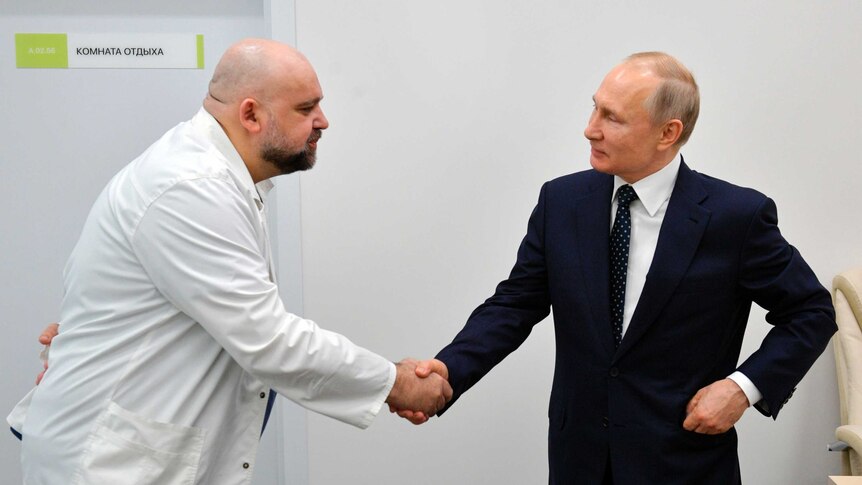 Vladimir Putin shakes hands with the hospital's chief Denis Protsenko during his visit on March 23.