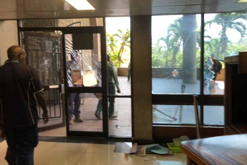 Holes in a glass window and door at PNG Parliament.