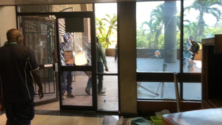 Holes in a glass window and door at PNG Parliament.